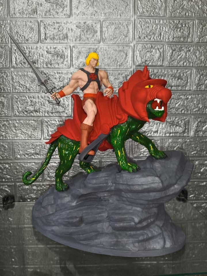 Diorama de He-Man montado em Battle Cat sobre base rochosa